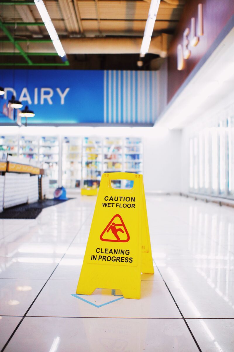 Wet floor sign standing in a freshly mopped common corridor